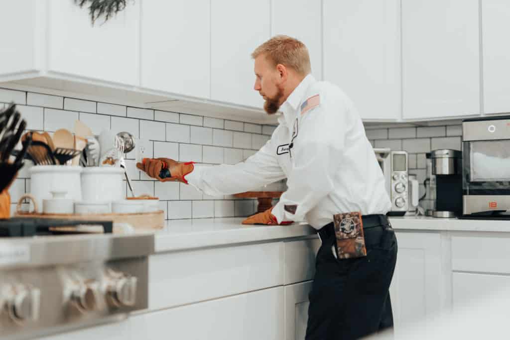 electrician testing outlet in kitchen