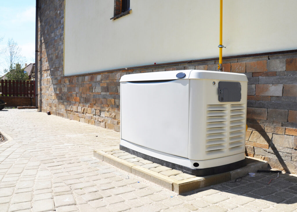 Standby generator outside of white stucco and brick home